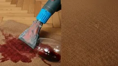 Vloerkleed wordt schoongemaakt na rode wijnvlek verwijdering met tapijtreiniger.