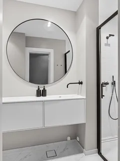 Witte badkamer met grote ronde spiegel