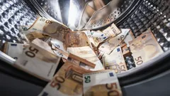 Vijftig eurobiljetten in een wasmachine, symbool voor het witwassen van geld.