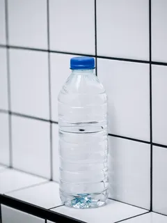doorzichtige plastic fles op witte keramische tegels