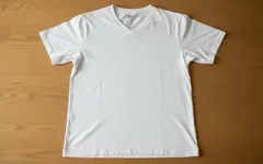 Witte T-shirt met V-hals op houten ondergrond, basic en casual kledingstijl.