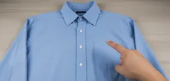 Blauwe overhemd met hand die op borstzak wijst, kledingstukken, nette blouse, strijkvrij.