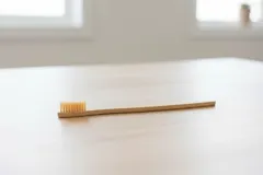 Bamboe tandenborstel op houten tafel in een lichte kamer, milieuvriendelijk alternatief