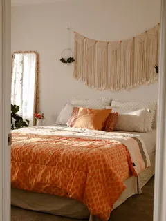 Boho slaapkamer met zonlicht en geel dekbedovertrek